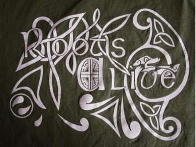 The Roots Alive logo in white on a dark green background. The logo says Roots Alive and is surrounded by celtic knot-style artwork.