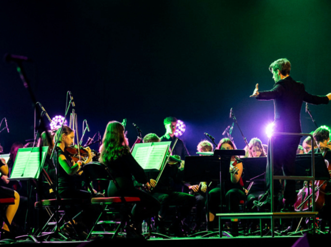 City of Leeds Youth Orchestra playing on the Leeds arena stage.